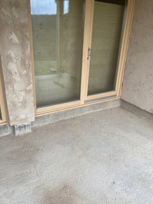 La baie vitrée de la cuisine une fois installée sur le relevé en béton