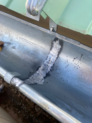 Soudure terminée entre deux morceaux de gouttières en zinc